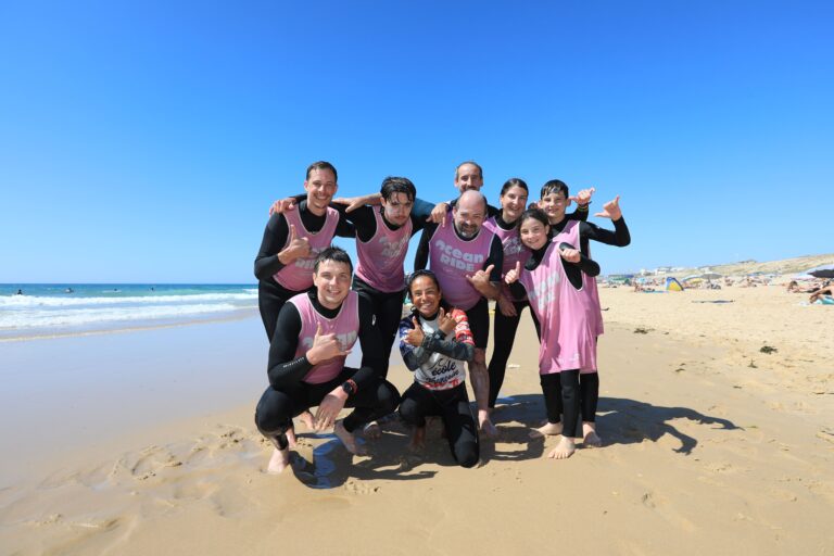 several people standing a lacanau beach after surfing
