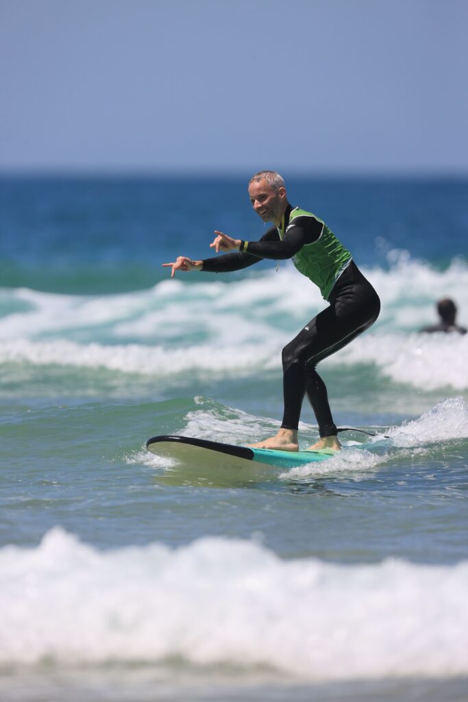 un homme se tient debout sur une planche de surf